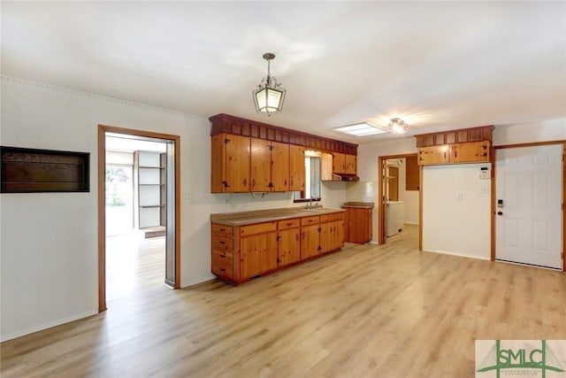 12445 Deerfield Rd, Savannah, GA 31419 - kitchen featuring a sink, plenty of natural light, light wood-style floors, and brown cabinets