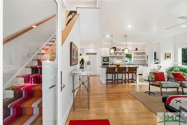 1111 Laurel Ave, Tybee Island, GA 31328 - living area with light wood finished floors, stairway, and recessed lighting