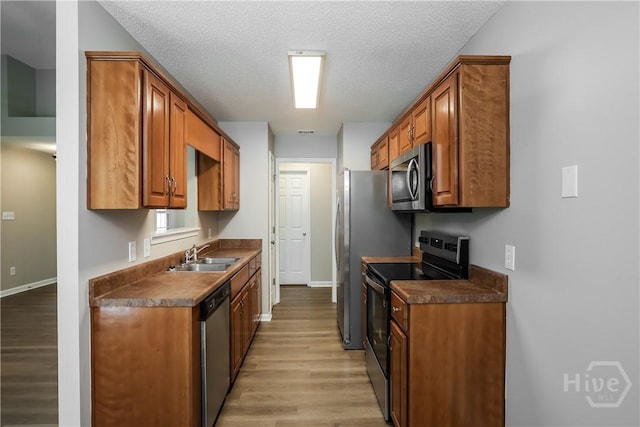 111 Tappan Zee Dr, Pooler, GA 31322 - kitchen with stainless steel appliances, a sink, dark countertops, light wood-type flooring, and a textured ceiling