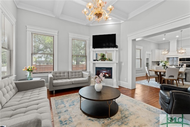 living room featuring wood finished floors, a chandelier, and a fireplace with flush hearth