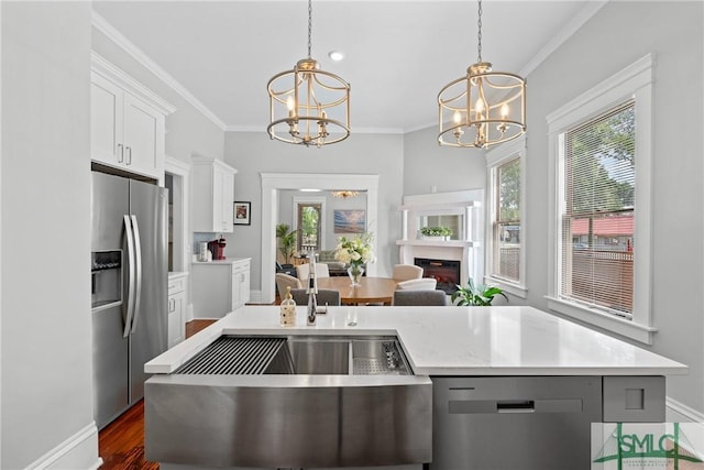 kitchen with crown molding, white cabinetry, a chandelier, appliances with stainless steel finishes, and light countertops