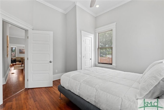bedroom with baseboards, ornamental molding, and hardwood / wood-style flooring