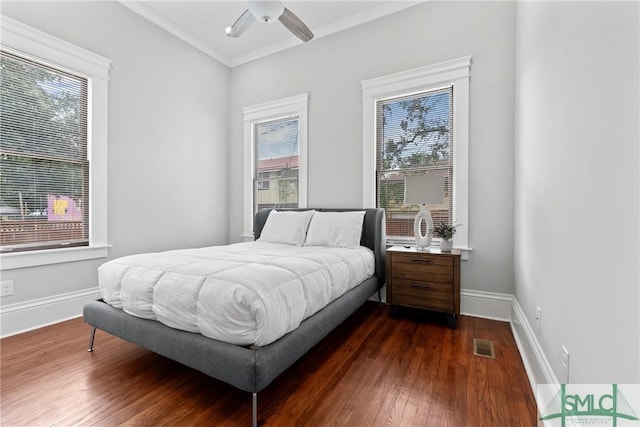 bedroom featuring visible vents, multiple windows, baseboards, and dark wood finished floors