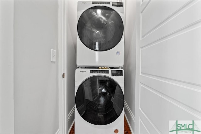 washroom with stacked washing maching and dryer and laundry area