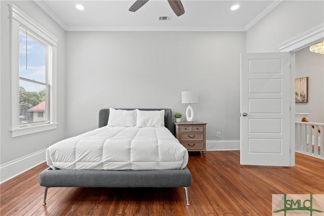 bedroom with wood finished floors, baseboards, ornamental molding, and visible vents