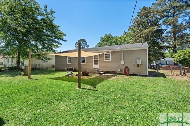 back of house with fence and a lawn