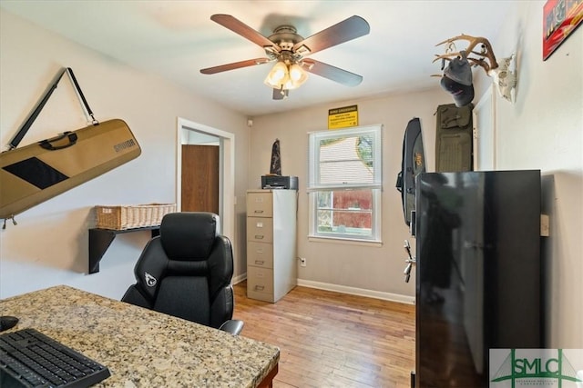 home office with light wood-style floors, baseboards, and a ceiling fan
