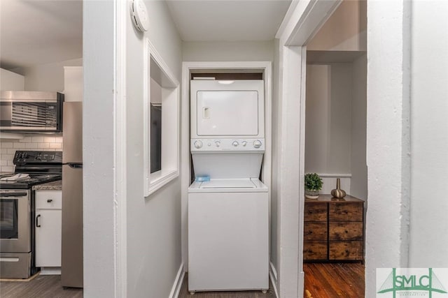 laundry area featuring stacked washing maching and dryer and dark wood finished floors