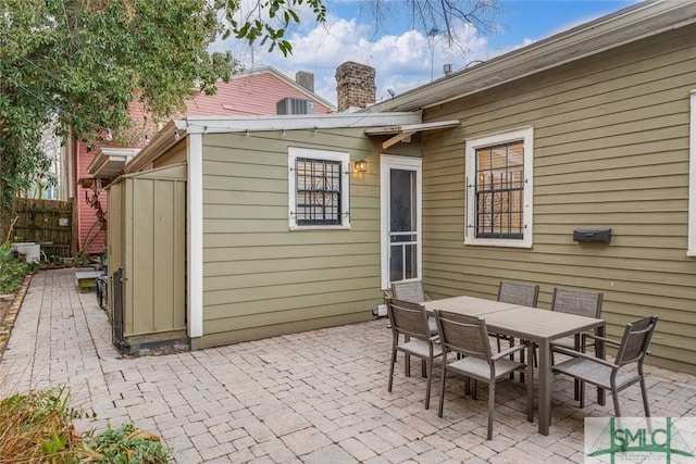 view of patio with outdoor dining space and fence