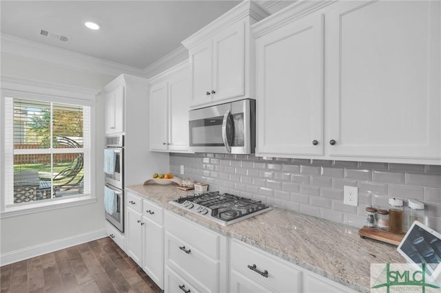 kitchen featuring white cabinets, dark wood-type flooring, stainless steel appliances, and visible vents