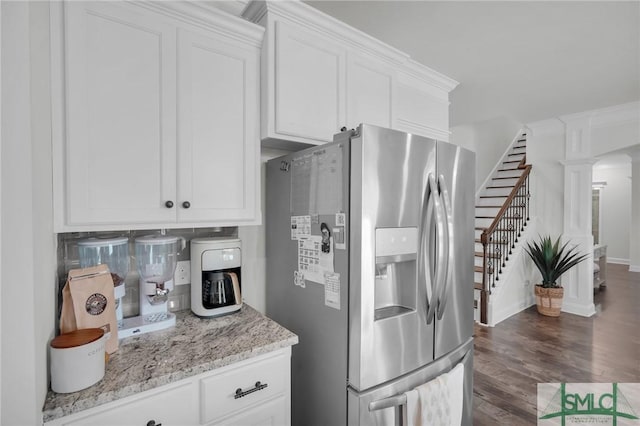 kitchen with stainless steel fridge with ice dispenser, ornate columns, white cabinetry, light stone countertops, and dark wood-type flooring