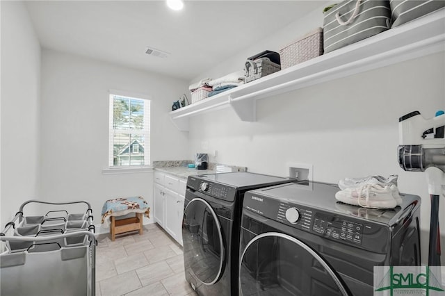 clothes washing area with cabinet space, visible vents, independent washer and dryer, and baseboards