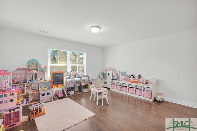 rec room with visible vents, baseboards, and wood finished floors