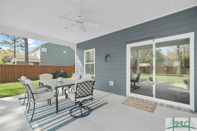 view of patio / terrace featuring outdoor dining space, fence, and a ceiling fan
