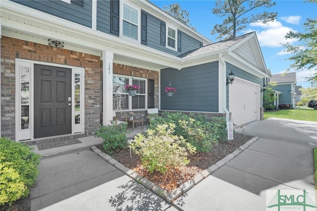 view of exterior entry with an attached garage, stone siding, covered porch, and driveway