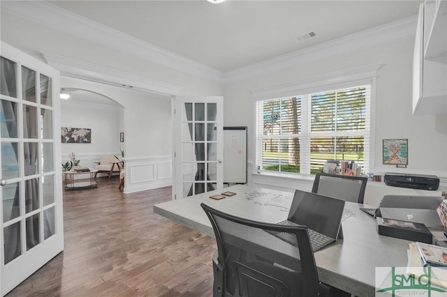 office space with crown molding, arched walkways, a wainscoted wall, wood finished floors, and french doors