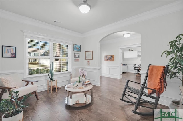 sitting room featuring crown molding, a wainscoted wall, visible vents, arched walkways, and wood finished floors