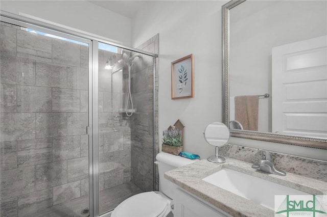 bathroom featuring toilet, a stall shower, and vanity