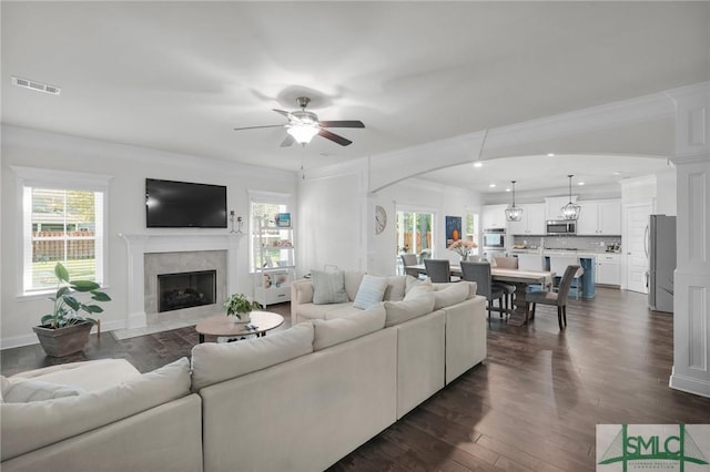 living room featuring a ceiling fan, a fireplace, dark wood-type flooring, visible vents, and recessed lighting