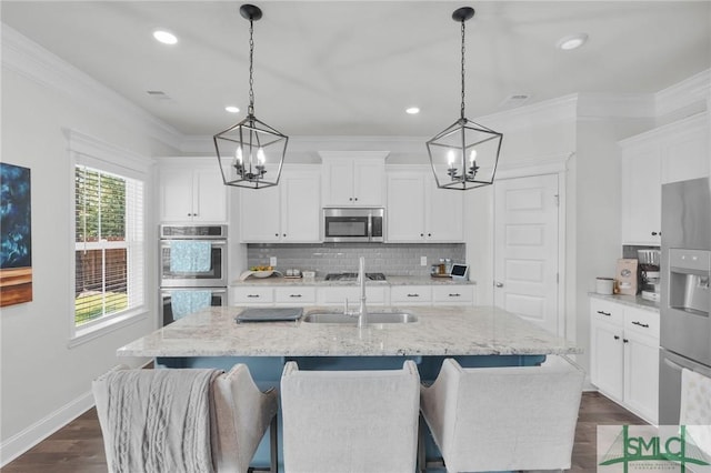 kitchen featuring stainless steel appliances, tasteful backsplash, an inviting chandelier, and dark wood finished floors