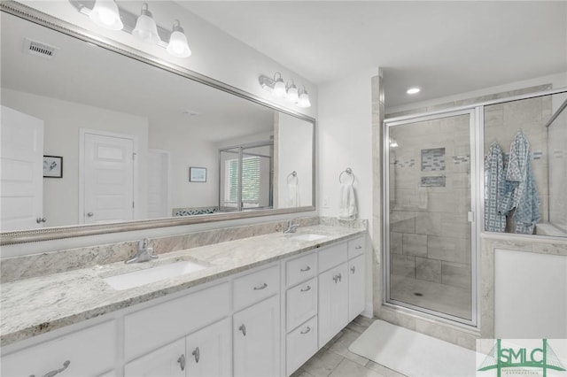 full bath featuring visible vents, a sink, and a shower stall