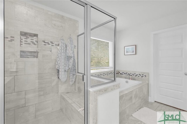 bathroom with a shower stall, a bath, and tile patterned flooring