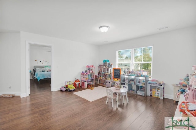 recreation room featuring baseboards, wood finished floors, and visible vents