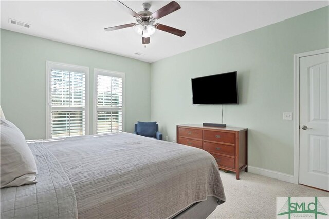 bedroom featuring visible vents, baseboards, ceiling fan, and light carpet
