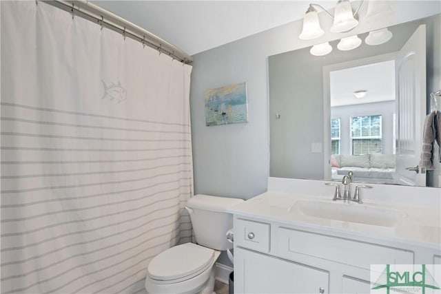 ensuite bathroom with toilet, vanity, and connected bathroom