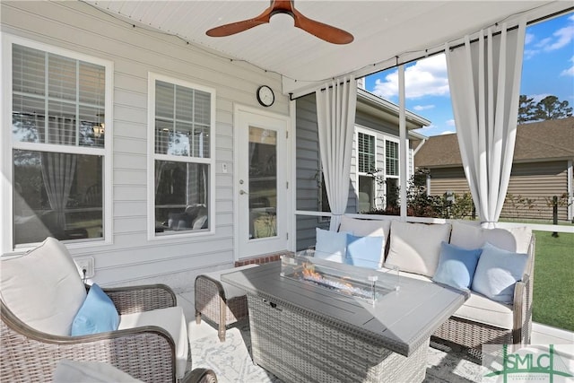 sunroom featuring an outdoor living space with a fire pit and ceiling fan