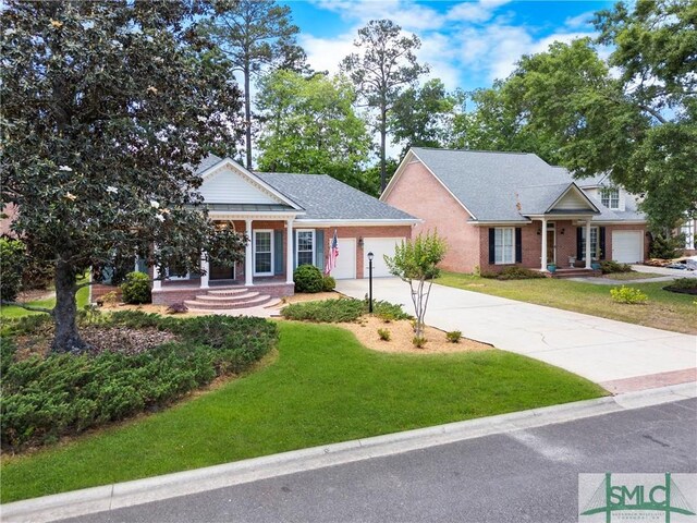 16 Oak Park Pt, Savannah, GA 31405 - view of front facade with a garage, covered porch, a front yard, brick siding, and concrete driveway