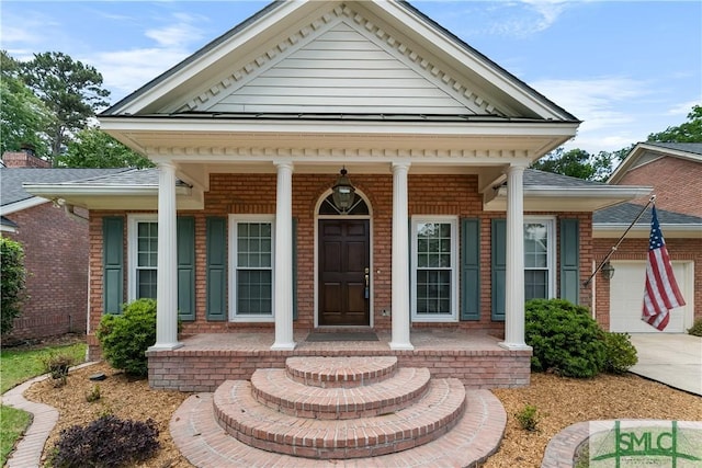 16 Oak Park Pt, Savannah, GA 31405 - view of front of home with covered porch, brick siding, driveway, and a garage