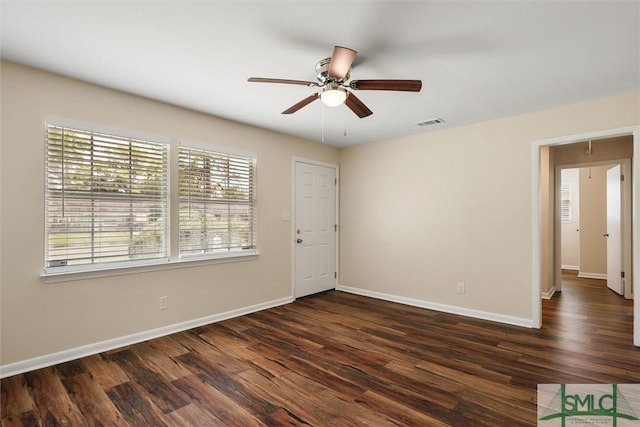 unfurnished room with dark wood-type flooring, ceiling fan, baseboards, and visible vents