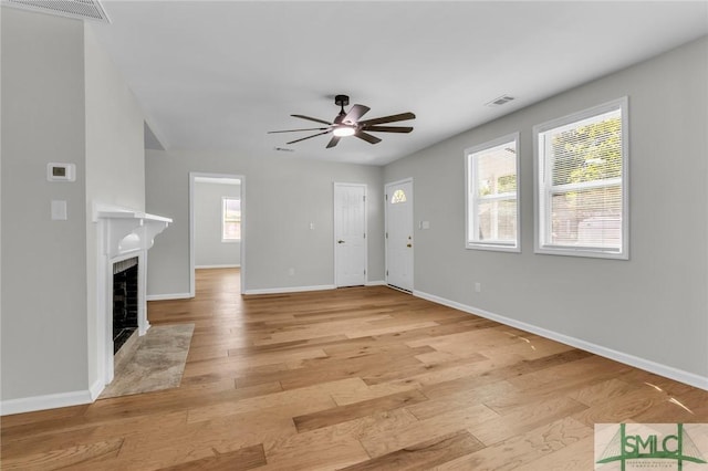 unfurnished living room with a ceiling fan, visible vents, and light wood-style floors
