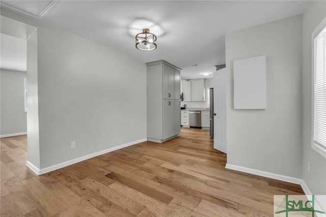 unfurnished dining area with baseboards and light wood-style flooring