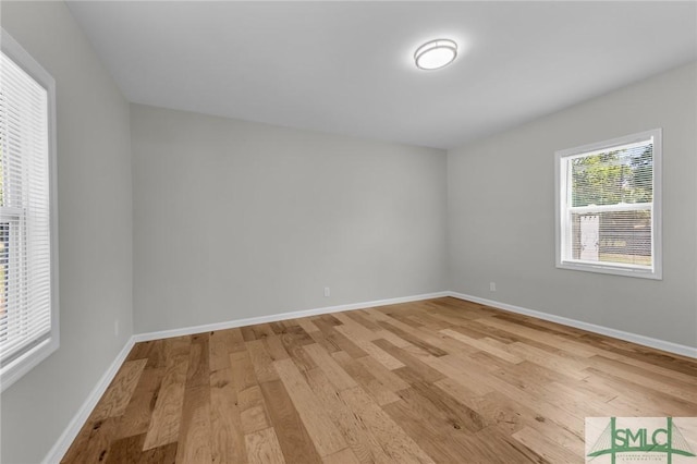 empty room with baseboards and light wood-style flooring