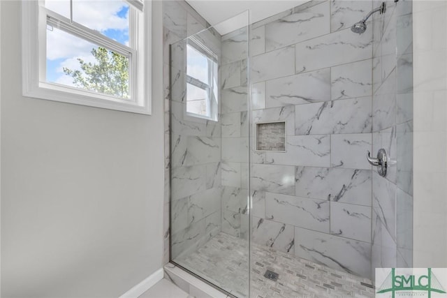 bathroom featuring baseboards and a marble finish shower