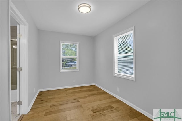 empty room with baseboards and light wood-type flooring
