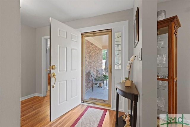 foyer entrance featuring light wood-style floors and baseboards