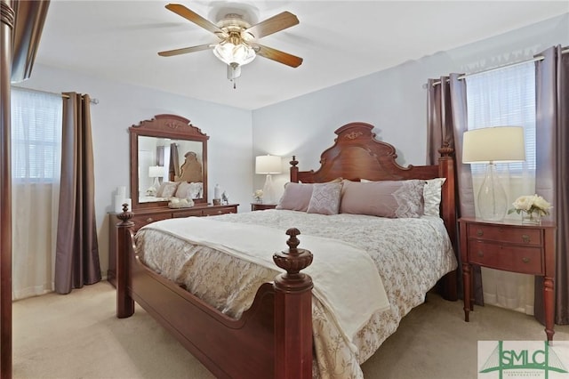 bedroom with ceiling fan, multiple windows, and light colored carpet