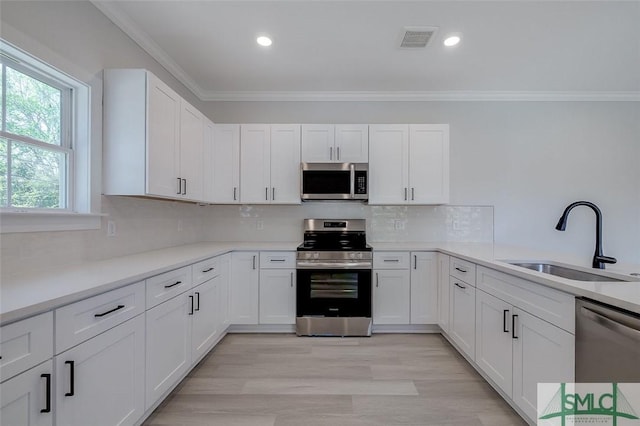 1615 Le Grand St, Savannah, GA 31401 - kitchen featuring visible vents, ornamental molding, a sink, appliances with stainless steel finishes, and white cabinetry