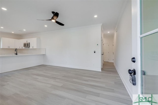 1615 Le Grand St, Savannah, GA 31401 - unfurnished living room featuring light wood-type flooring, ceiling fan, baseboards, ornamental molding, and recessed lighting