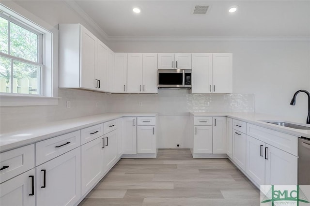 1615 Le Grand St, Savannah, GA 31401 - kitchen with stainless steel appliances, visible vents, a sink, and ornamental molding