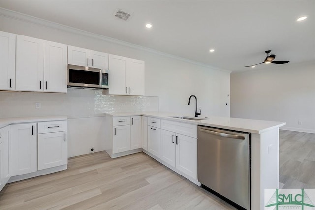 1615 Le Grand St, Savannah, GA 31401 - kitchen featuring a peninsula, a sink, visible vents, crown molding, and appliances with stainless steel finishes