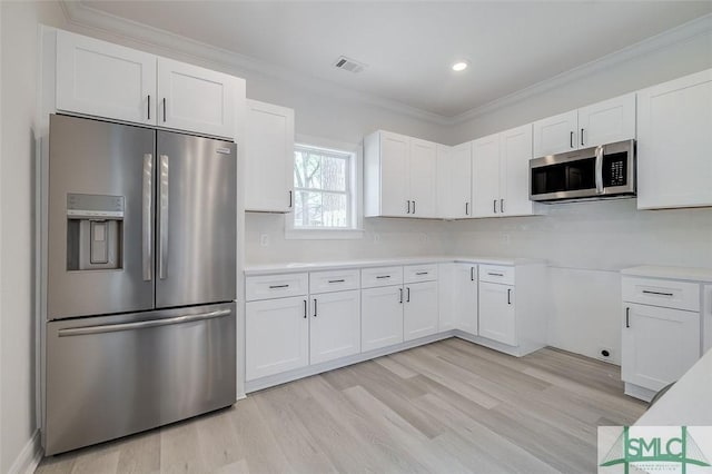 1615 Le Grand St, Savannah, GA 31401 - kitchen with white cabinets, appliances with stainless steel finishes, visible vents, and light wood-style flooring