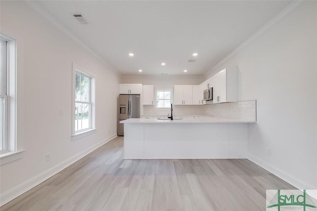 1615 Le Grand St, Savannah, GA 31401 - kitchen featuring light wood-style flooring, visible vents, crown molding, light countertops, and appliances with stainless steel finishes