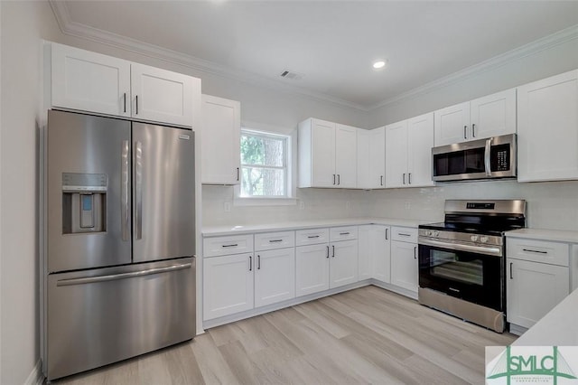 1615 Le Grand St, Savannah, GA 31401 - kitchen with light countertops, visible vents, light wood-style flooring, appliances with stainless steel finishes, and white cabinetry