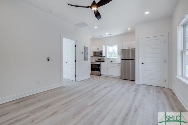 1615 Le Grand St, Savannah, GA 31401 - unfurnished living room featuring electric panel, light wood-type flooring, ceiling fan, baseboards, and visible vents