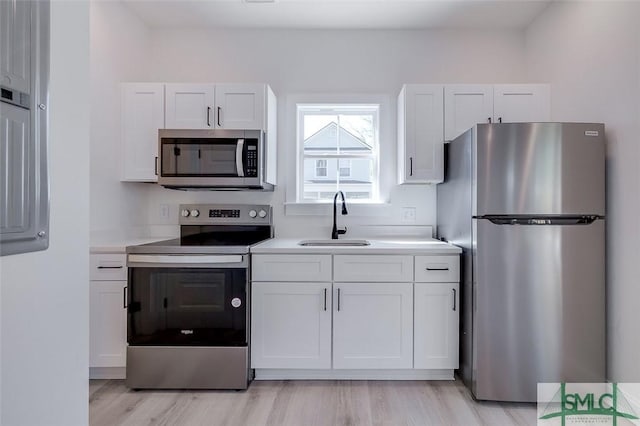 1615 Le Grand St, Savannah, GA 31401 - kitchen featuring stainless steel appliances, a sink, light wood-type flooring, white cabinetry, and light countertops