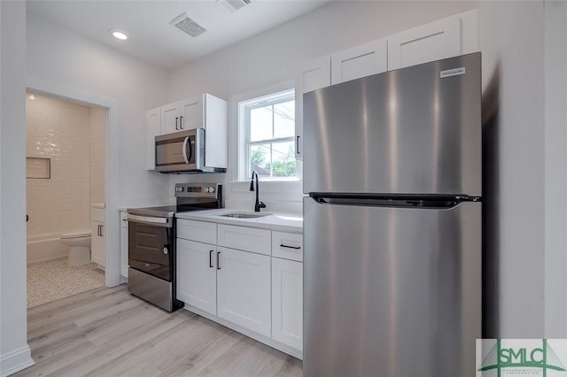 1615 Le Grand St, Savannah, GA 31401 - kitchen with a sink, light wood-style flooring, white cabinets, appliances with stainless steel finishes, and visible vents